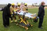 The Grim Reaper assists Lemoore Firefighters as they deliver an injured Mia Raber to a waiting helicopter that will deliver her to Adventist Hospital. It was part of a program entitled "Every 15 Minutes" that played to LHS students Thursday afternoon.